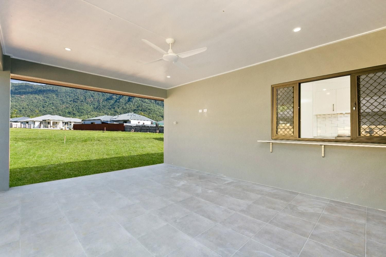 An Empty Room With a Ceiling Fan and a Window  — Ashlee Jones Homes in Gordonvale, QLD
