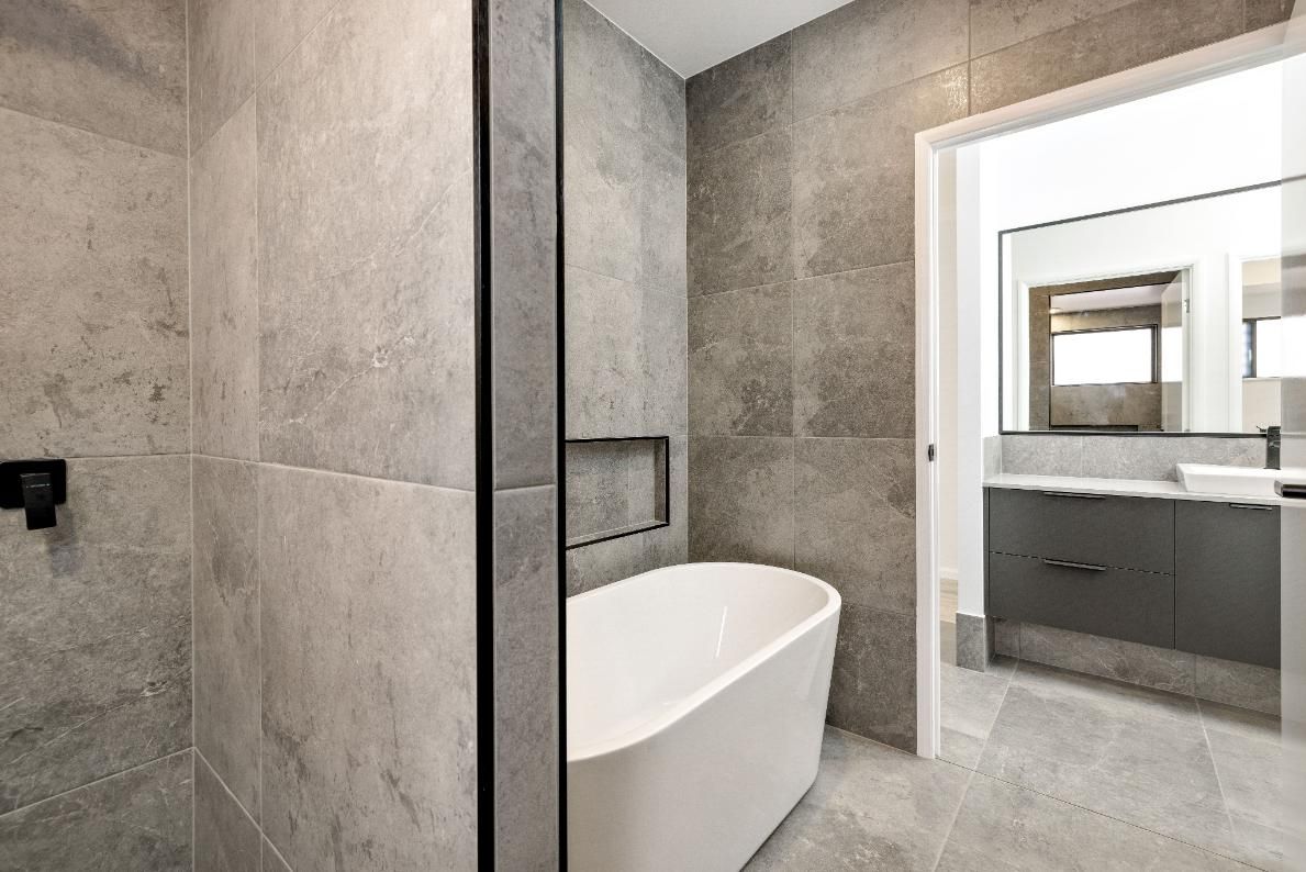 A Bathroom With a Bathtub and a Walk in Shower — Ashlee Jones Homes in Gordonvale, QLD