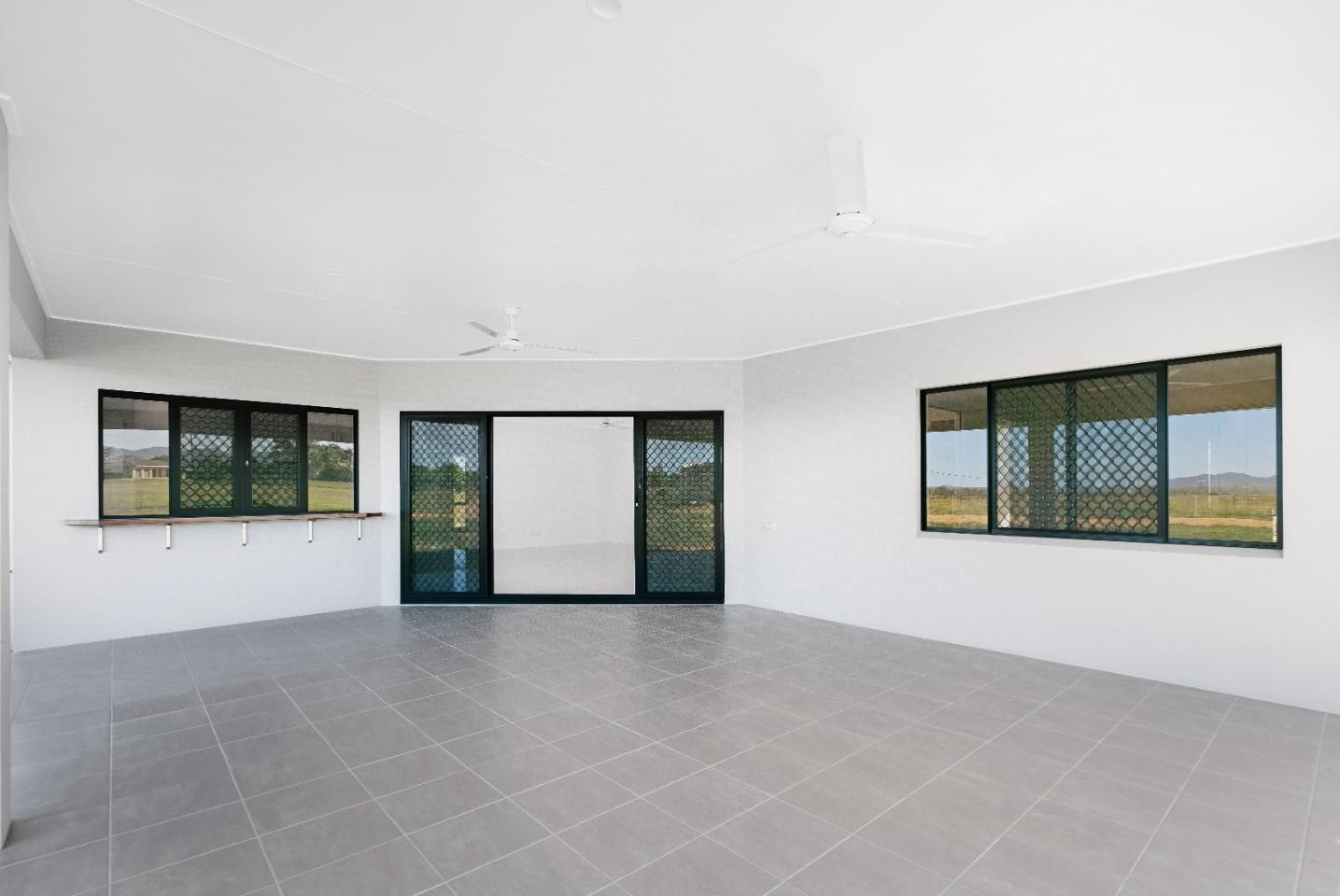 A Large Empty Room With a Lot of Windows and Doors — Ashlee Jones Homes in Gordonvale, QLD
