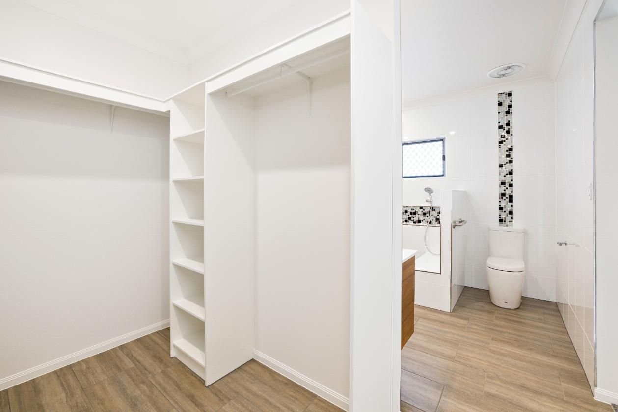 A Walk in Closet Next to a Bathroom With a Toilet — Ashlee Jones Homes in Gordonvale, QLD