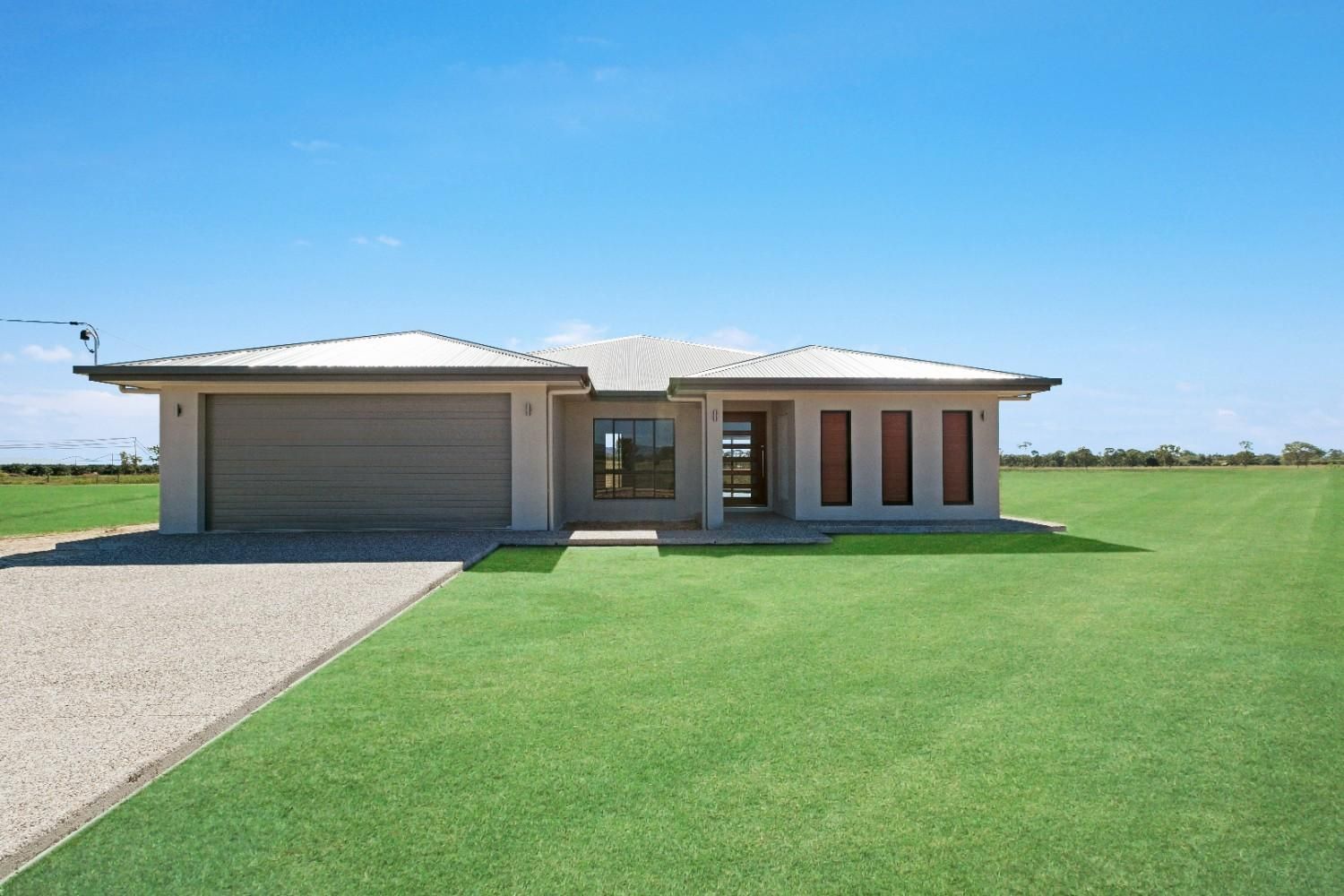 A White House With a Blue Roof and a Wooden Door is Sitting on Top of a Lush Green Lawn — Ashlee Jones Homes in Gordonvale, QLD