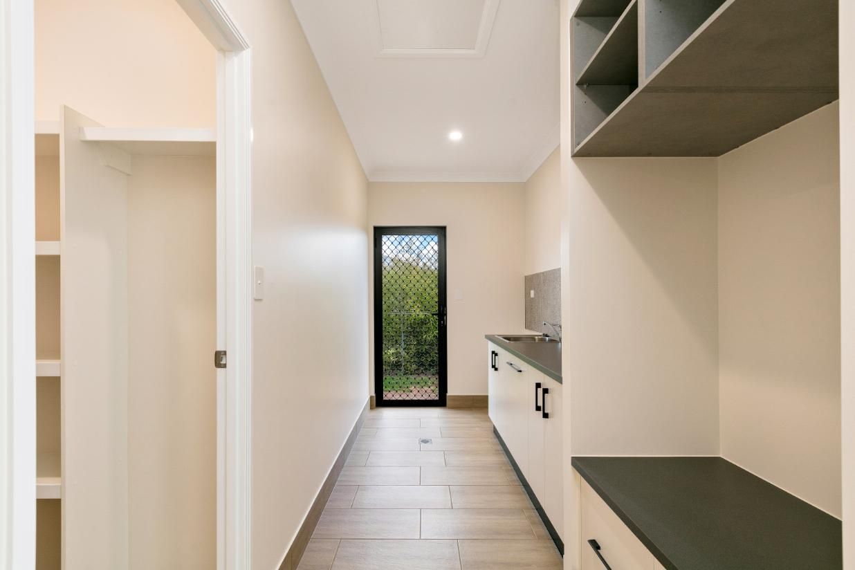 A Long Hallway With a Sink and Cabinets in a House — Ashlee Jones Homes in Gordonvale, QLD