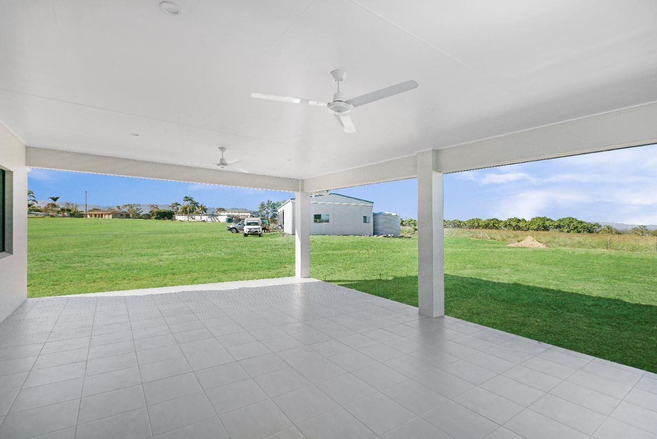 An Empty Patio With a Ceiling Fan and a View of a Grassy Field — Ashlee Jones Homes in Gordonvale, QLD