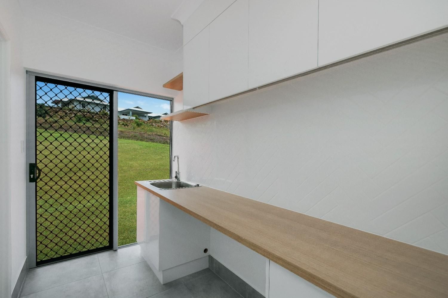A Kitchen With a Sink and a Wooden Counter Top — Ashlee Jones Homes in Gordonvale, QLD