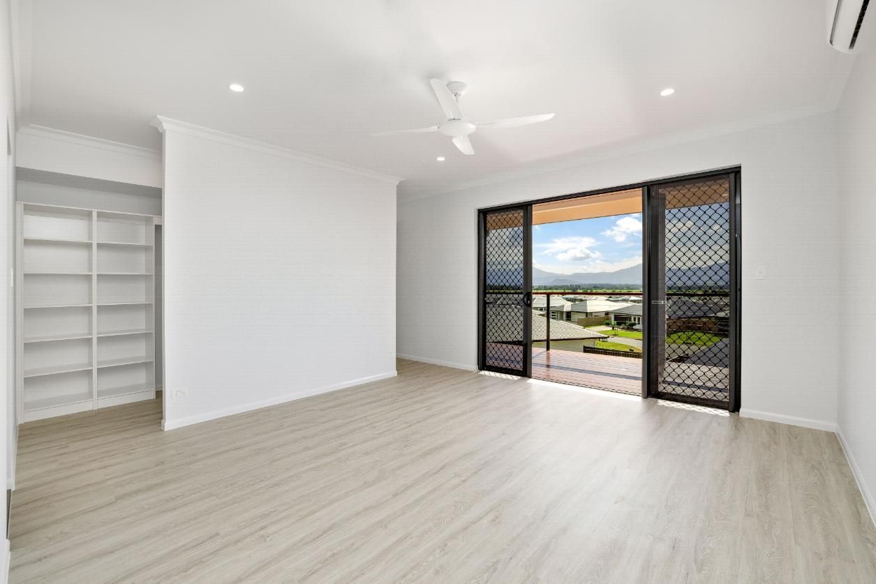An Empty Room With a Balcony and Sliding Glass Doors — Ashlee Jones Homes in Gordonvale, QLD