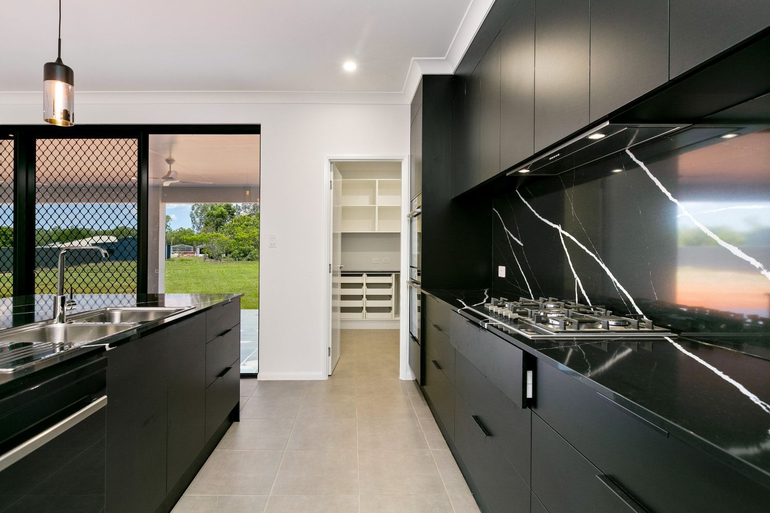 A Kitchen With Black Cabinets and Stainless Steel Appliances — Ashlee Jones Homes in Gordonvale, QLD