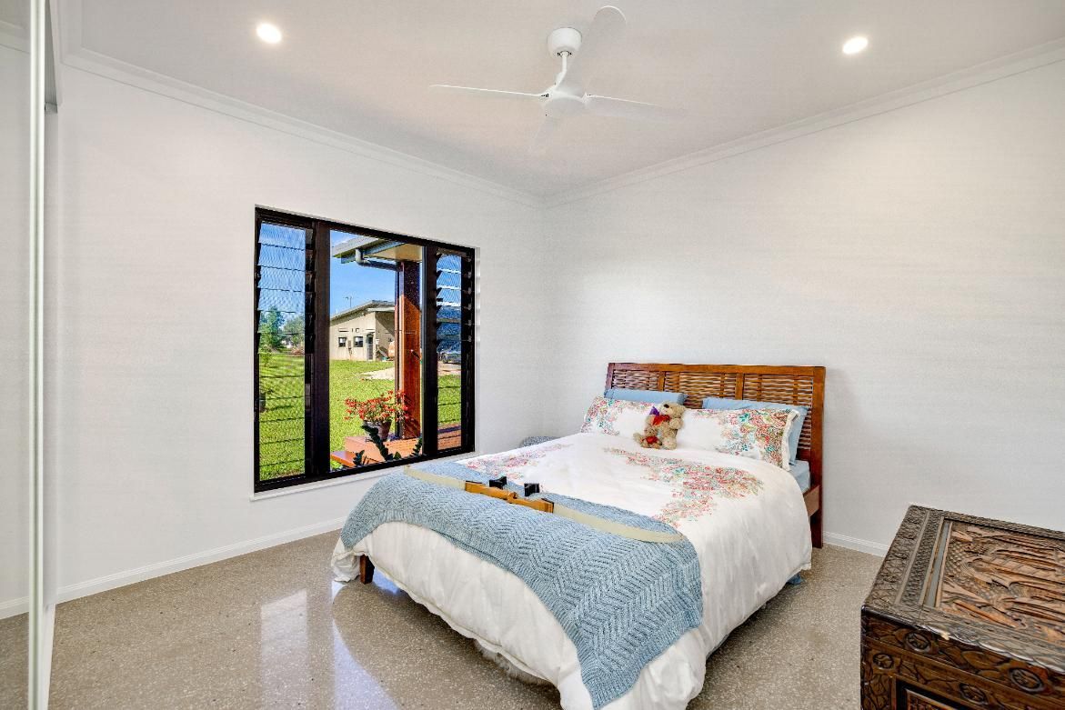 A Bedroom With a Bed, a Ceiling Fan, a Window and a Dresser — Ashlee Jones Homes in Gordonvale, QLD