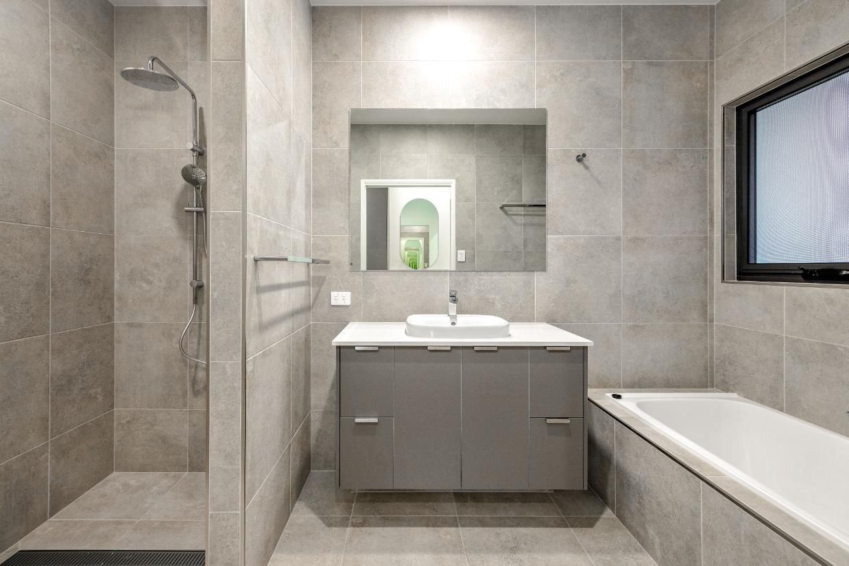 A Bathroom With a Sink, Tub, Shower and Mirror — Ashlee Jones Homes in Gordonvale, QLD
