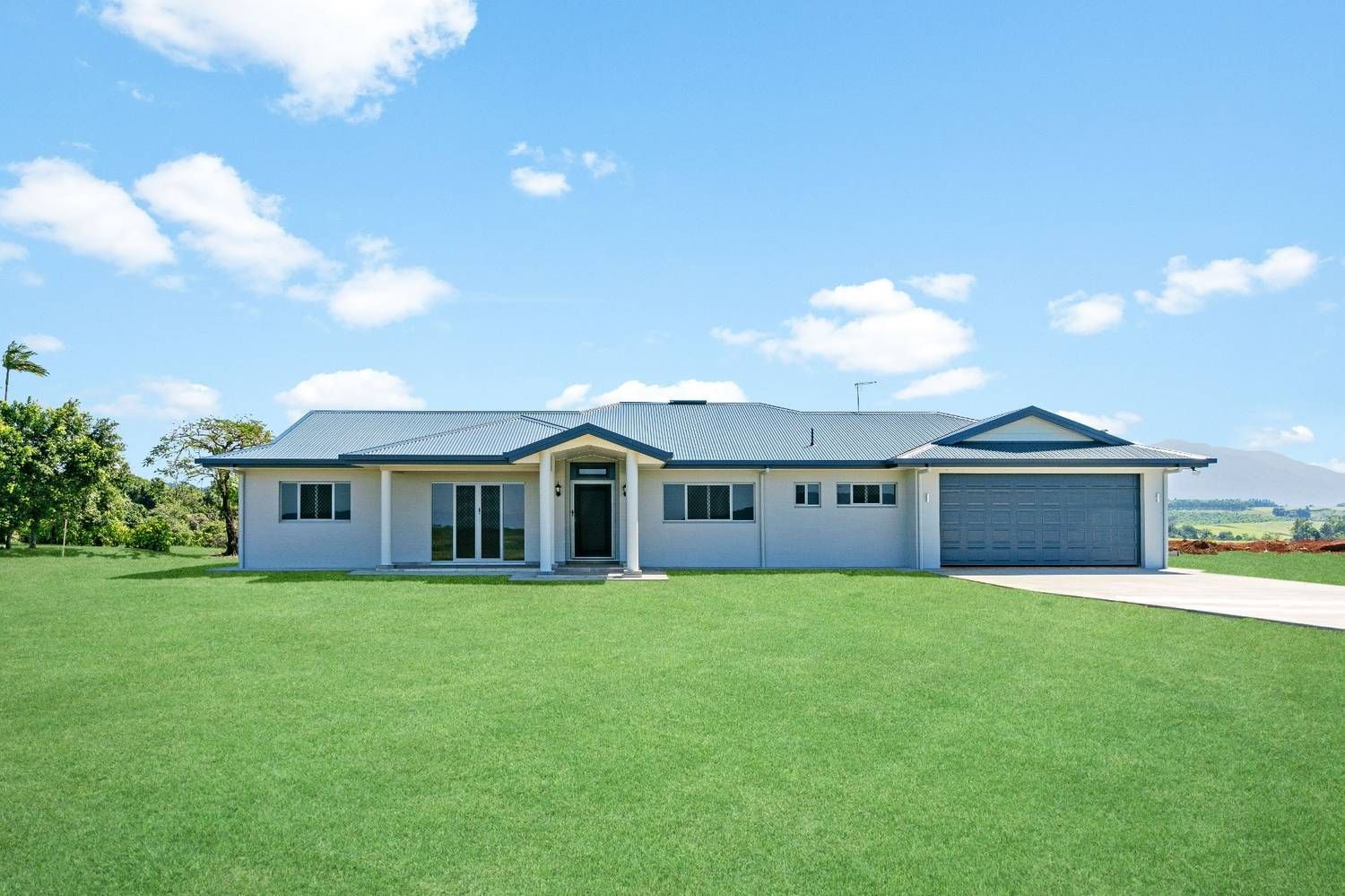 A Bathroom With Two Sinks, a Shower and a Window — Ashlee Jones Homes in Gordonvale, QLD