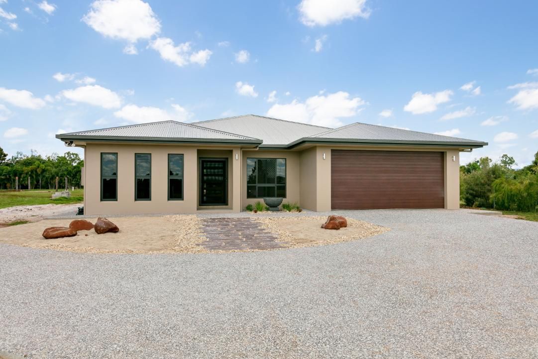 A House With a Garage and a Gravel Driveway in Front of It — Ashlee Jones Homes in Gordonvale, QLD