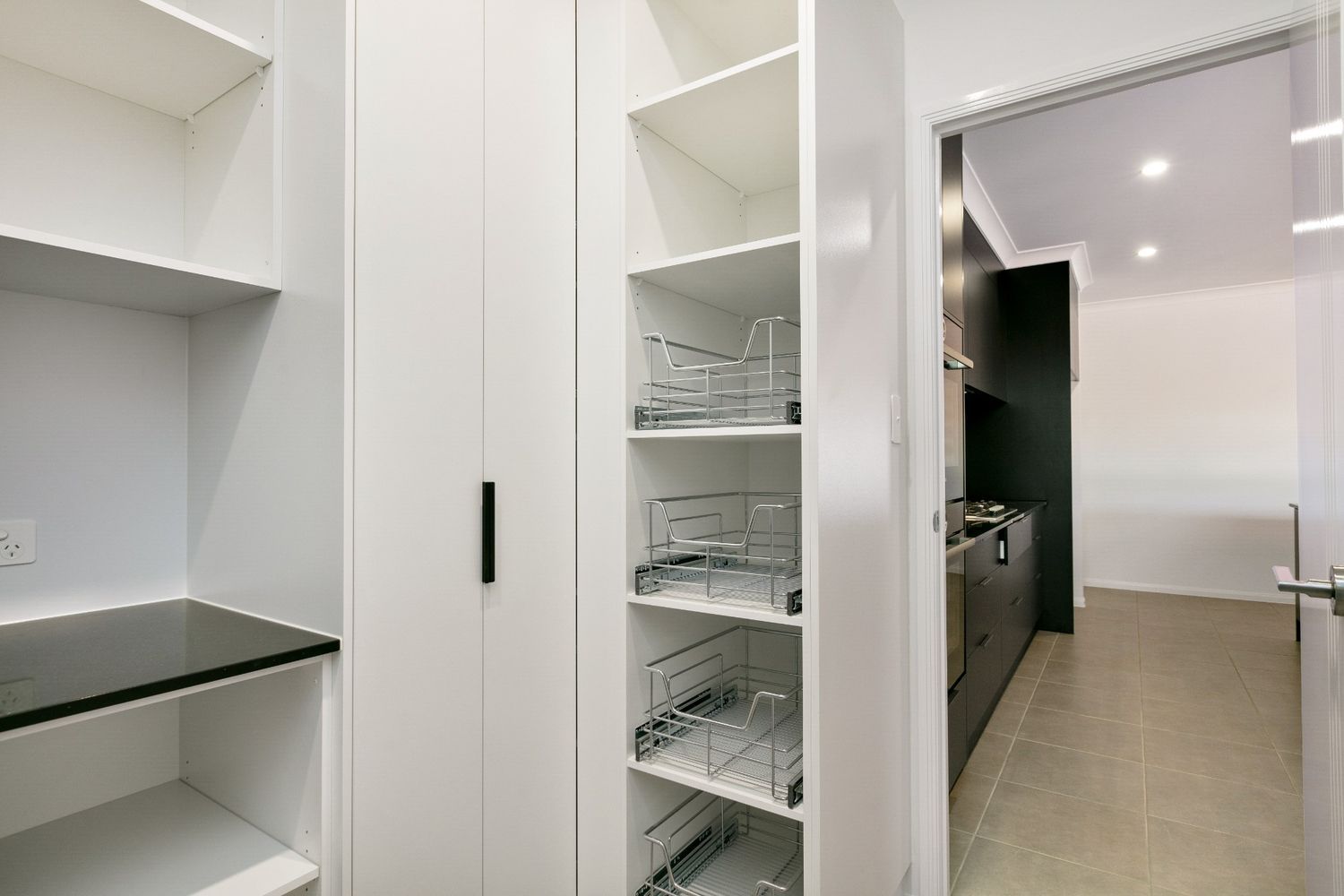 A Pantry With Lots of Shelves and a Door Leading to a Kitchen — Ashlee Jones Homes in Gordonvale, QLD