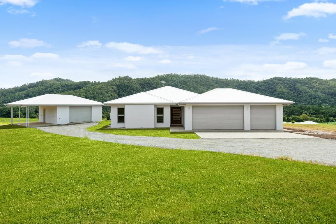 A White House is Sitting on Top of a Lush Green Field — Ashlee Jones Homes in Gordonvale, QLD