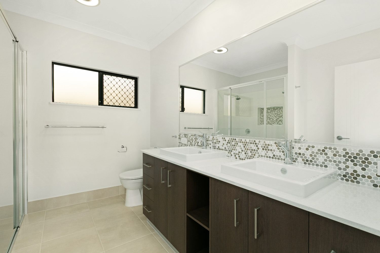 A Bathroom With Two Sinks, a Toilet and a Shower — Ashlee Jones Homes in Gordonvale, QLD