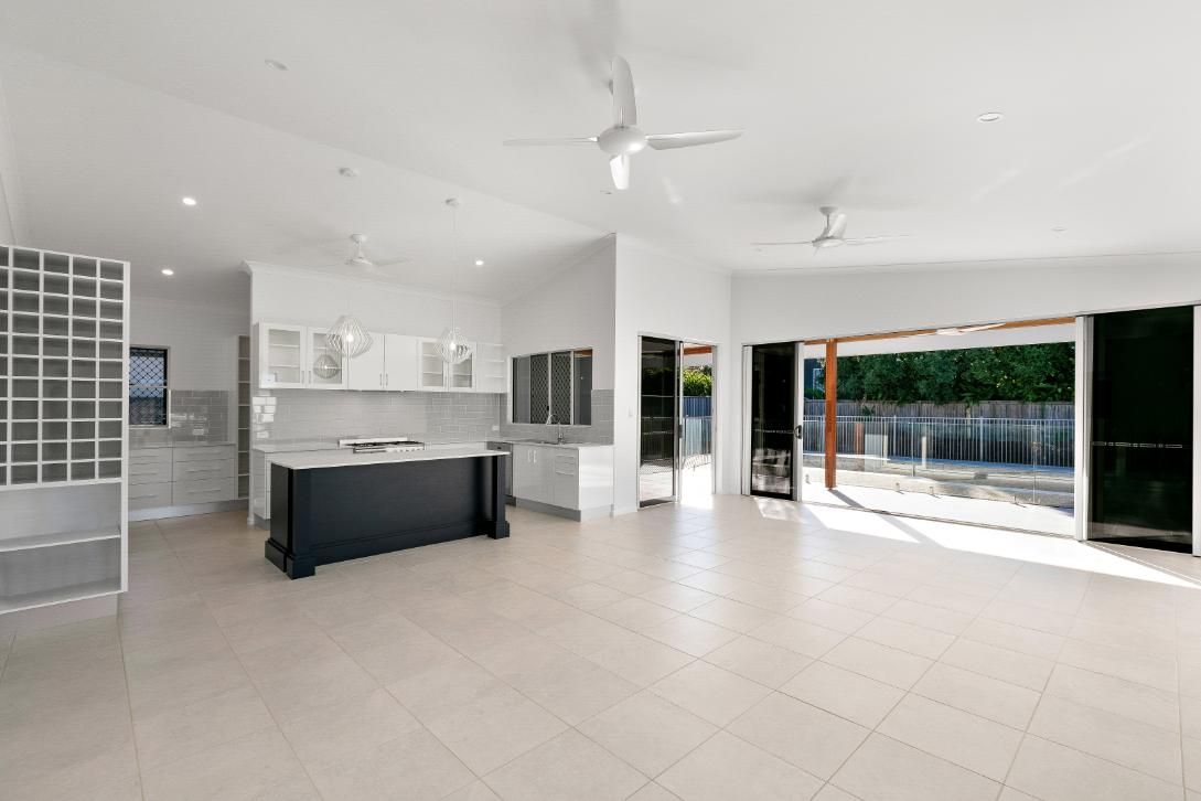 A Large Empty Room With a Kitchen and a Ceiling Fan — Ashlee Jones Homes in Gordonvale, QLD