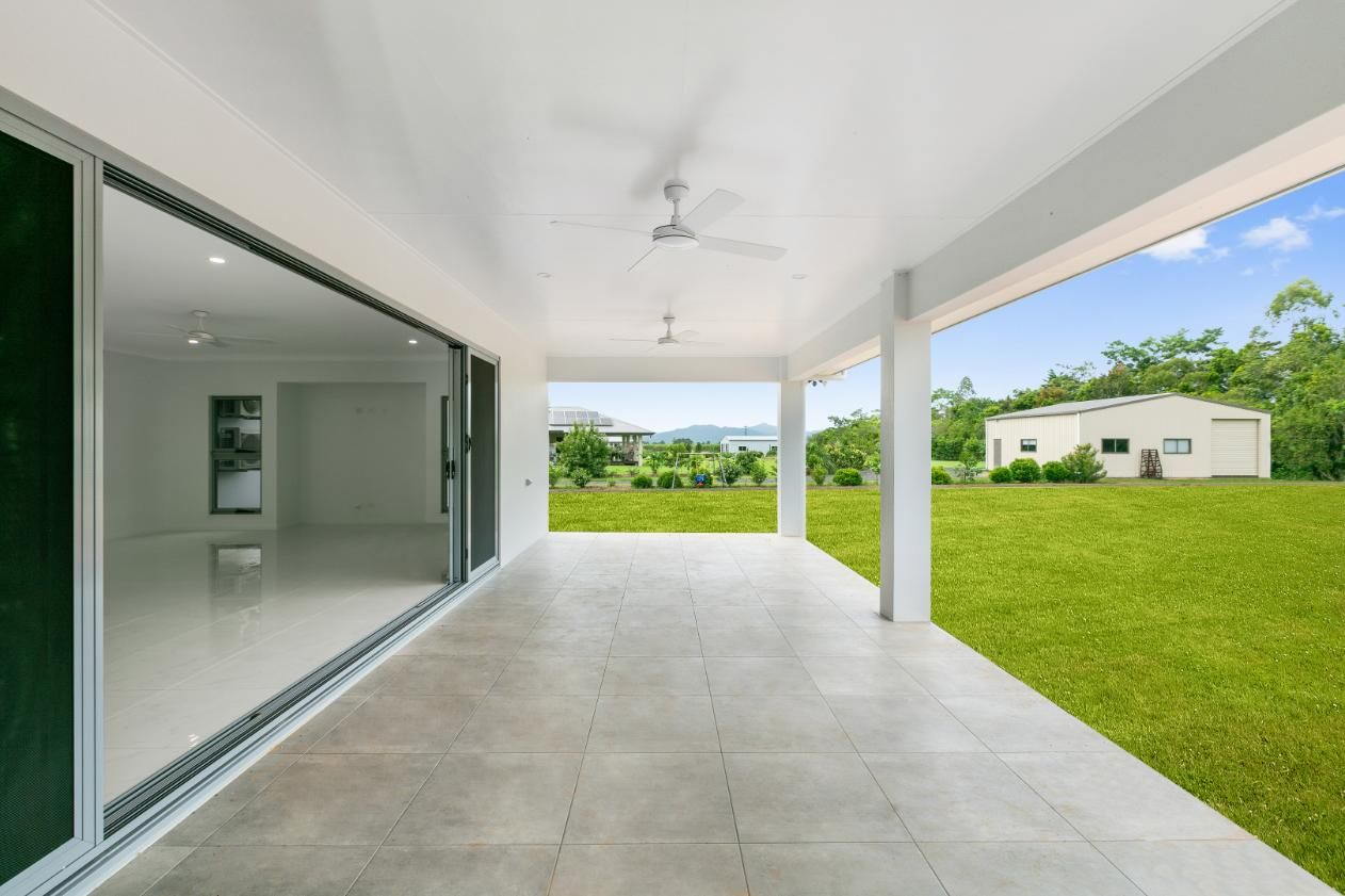 An Empty Patio With Sliding Glass Doors and a Ceiling Fan — Ashlee Jones Homes in Gordonvale, QLD