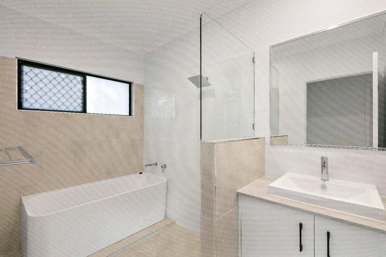 A Bathroom With a Bathtub, Sink, Mirror and Shower — Ashlee Jones Homes in Gordonvale, QLD
