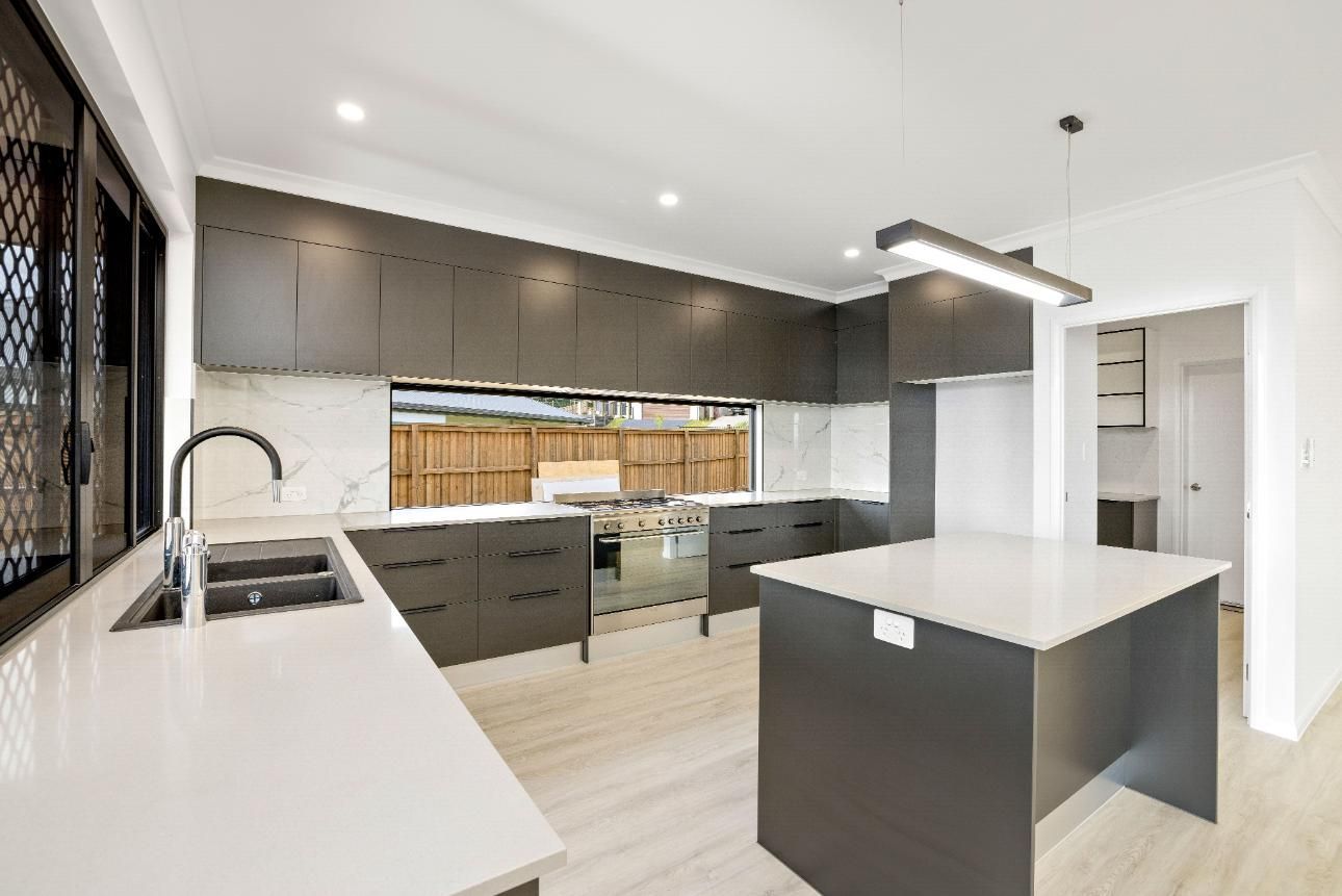 A Kitchen With a Large Island in the Middle and a Sink — Ashlee Jones Homes in Gordonvale, QLD