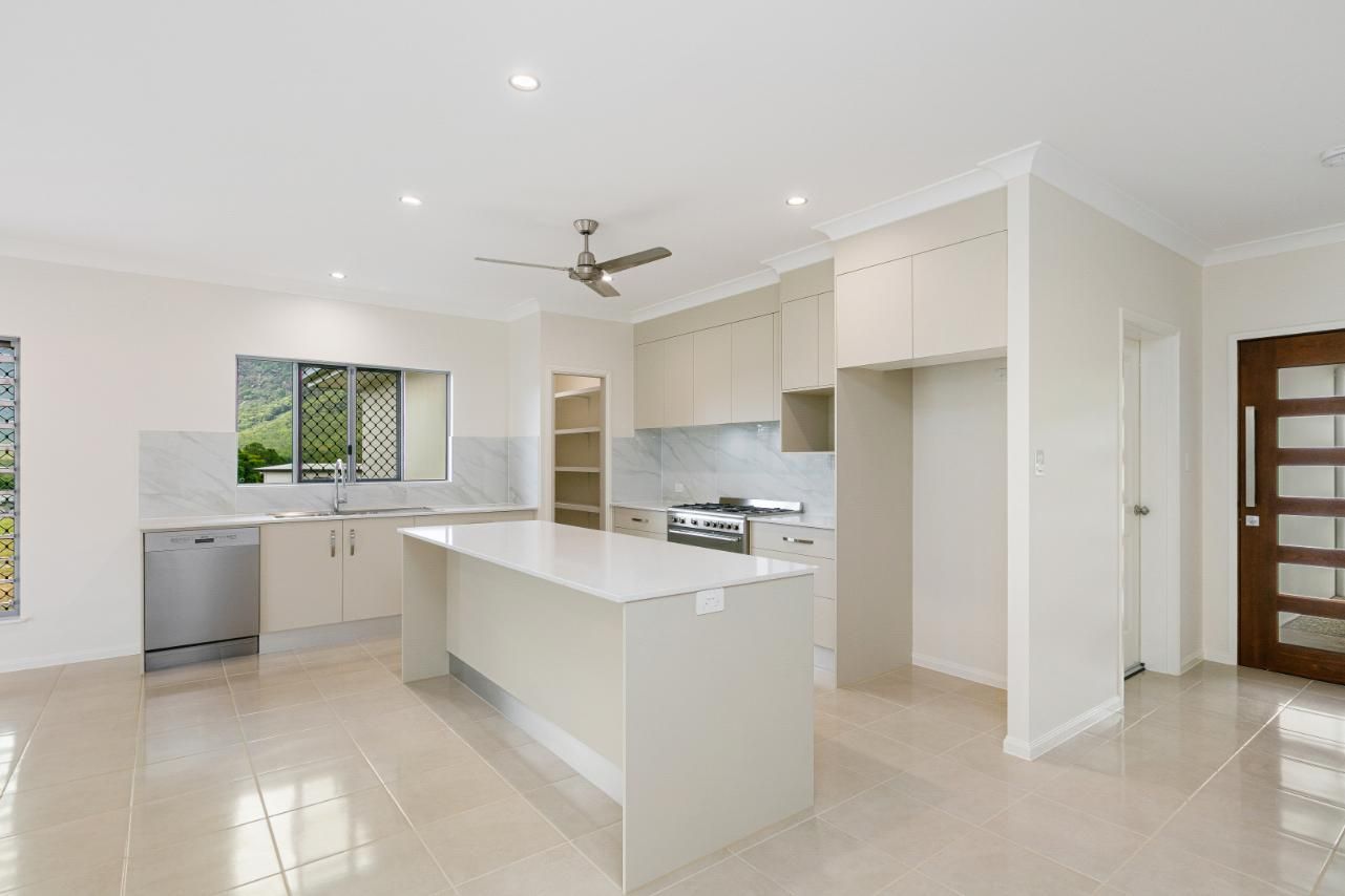 A Kitchen With a Large Island and a Ceiling Fan — Ashlee Jones Homes in Gordonvale, QLD