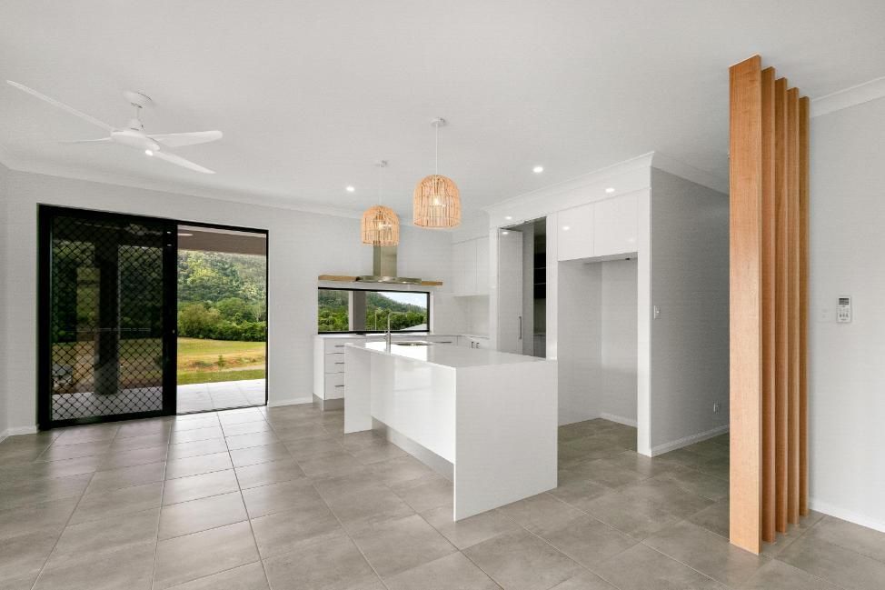 An Empty Kitchen With a Large Island in the Middle of the Room — Ashlee Jones Homes in Gordonvale, QLD