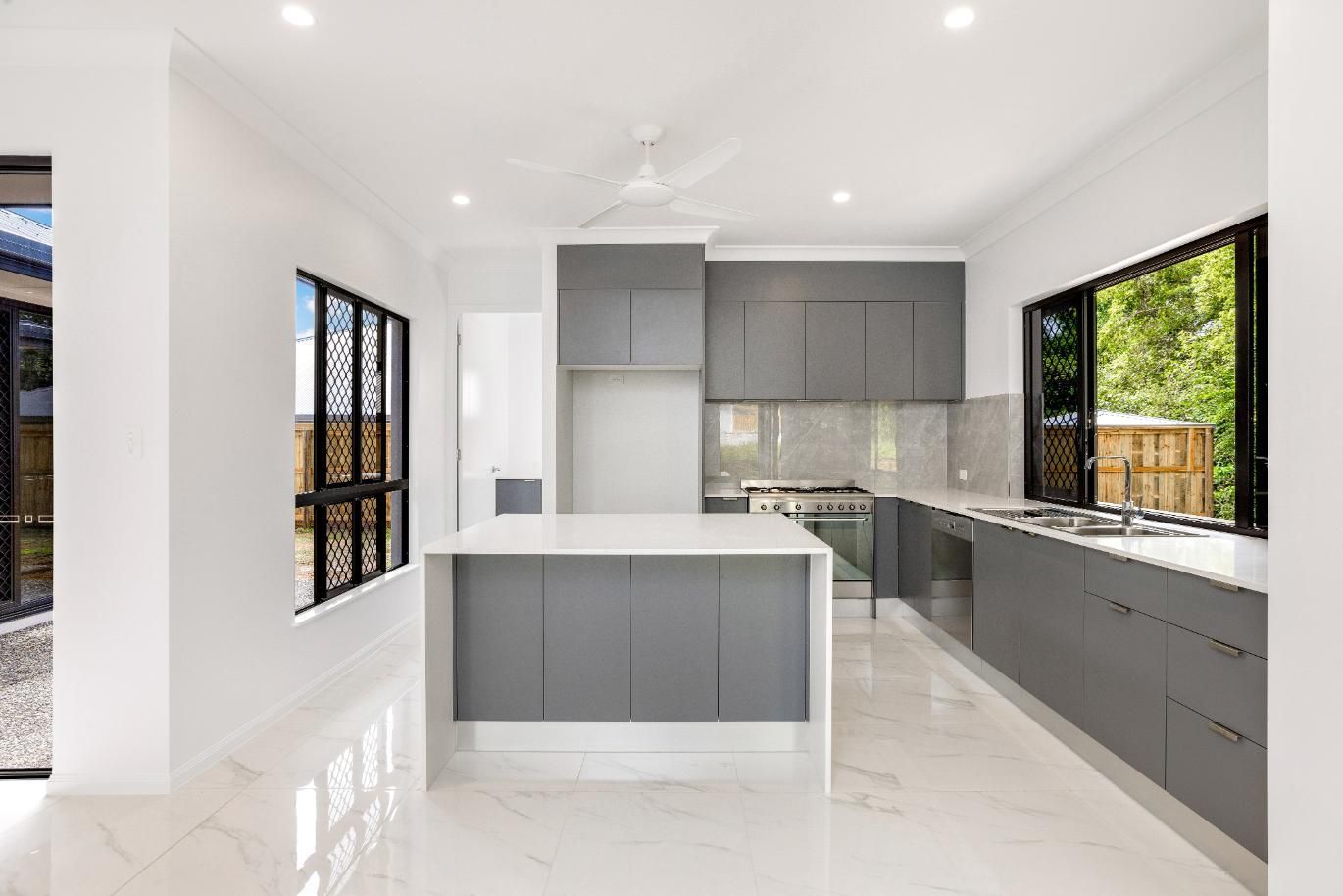 A Kitchen With a Large Island and a Lot of Windows — Ashlee Jones Homes in Gordonvale, QLD