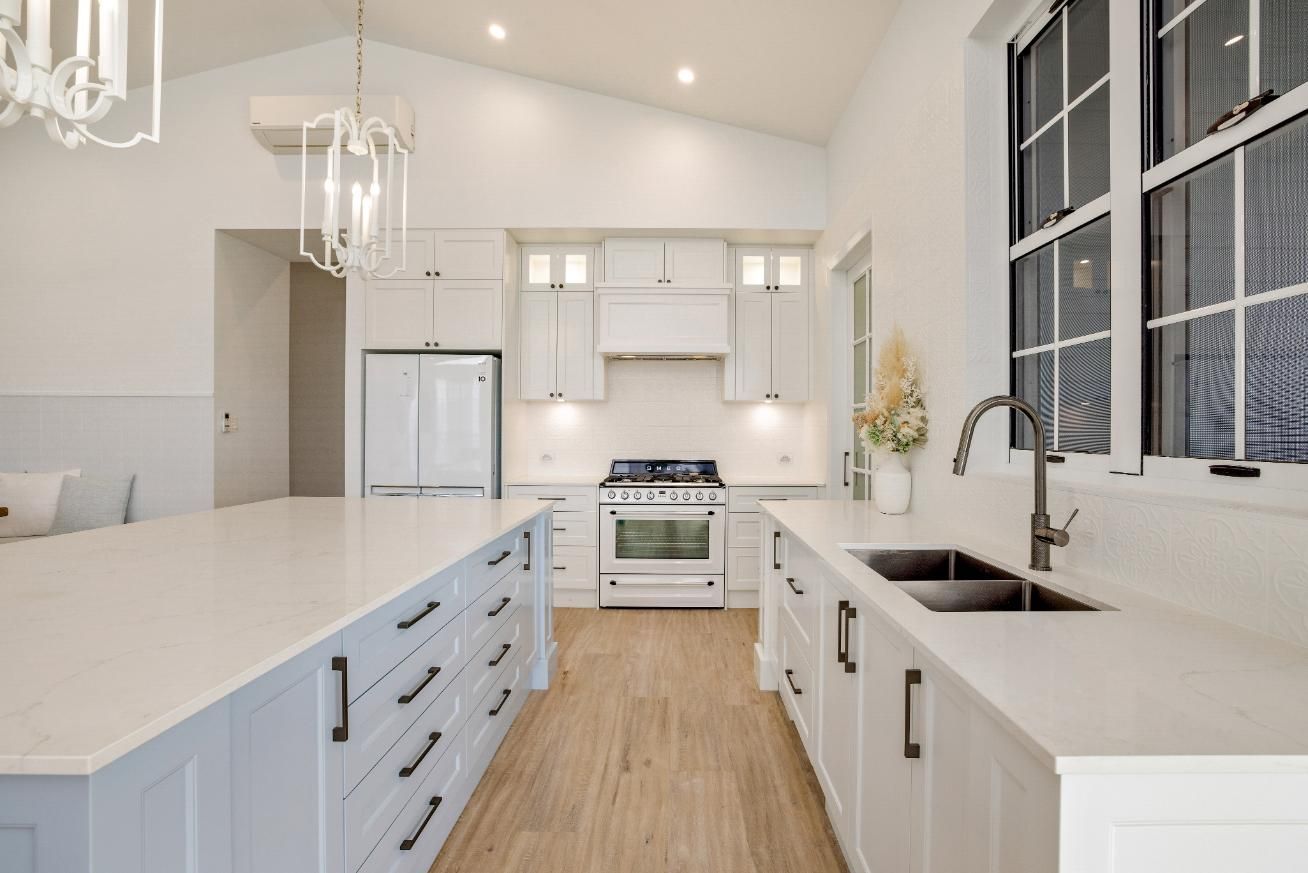A Kitchen With White Cabinets, a Sink, and a Stove — Ashlee Jones Homes in Gordonvale, QLD