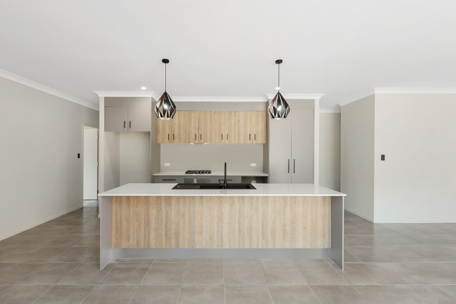 An Empty Kitchen With a Large Island in the Middle of the Room — Ashlee Jones Homes in Gordonvale, QLD