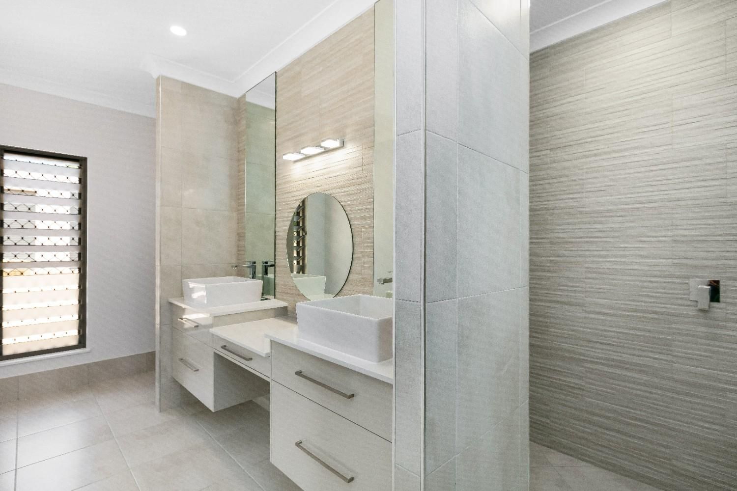 A Bathroom With Two Sinks, a Mirror and a Walk in Shower — Ashlee Jones Homes in Gordonvale, QLD