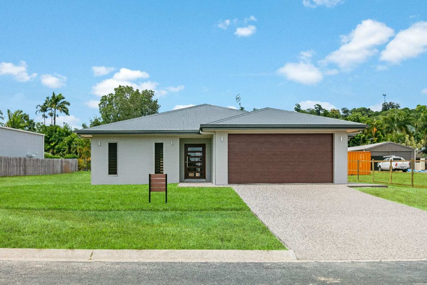 A White House With a Brown Garage Door — Ashlee Jones Homes in Gordonvale, QLD