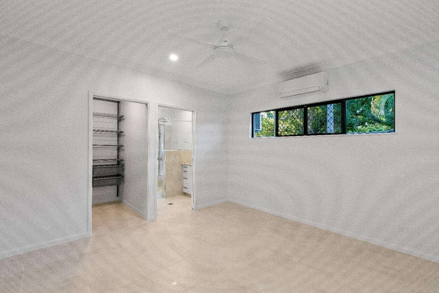 An Empty Room With a Painting on the Wall and a Ceiling Fan — Ashlee Jones Homes in Gordonvale, QLD