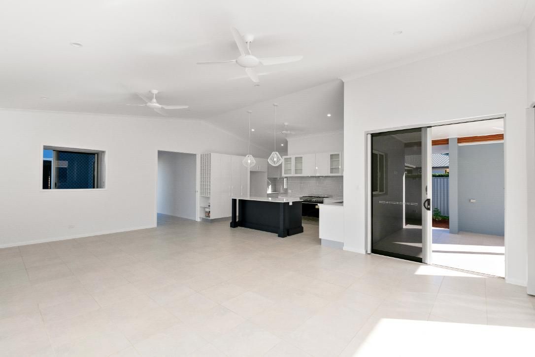 A Large Empty Room With a Kitchen and a Ceiling Fan — Ashlee Jones Homes in Gordonvale, QLD