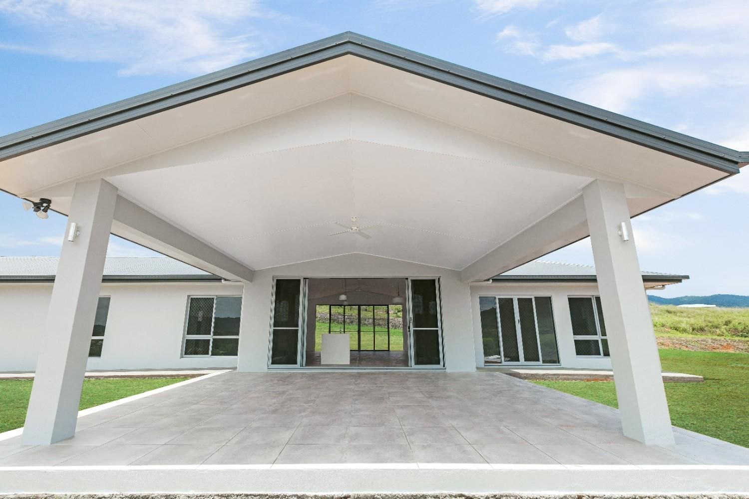 A Large White House With a Large Driveway Leading to It — Ashlee Jones Homes in Gordonvale, QLD