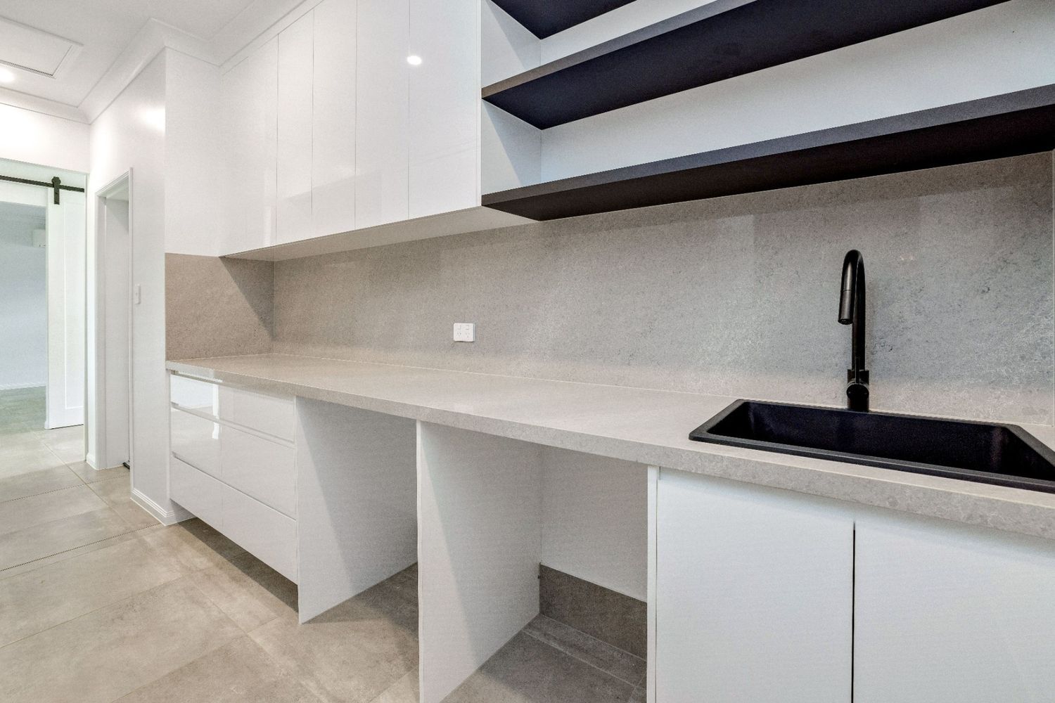 A Kitchen With White Cabinets and a Black Sink — Ashlee Jones Homes in Gordonvale, QLD