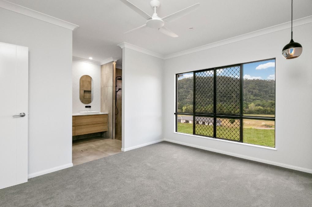 An Empty Bedroom With a Ceiling Fan and a Large Window — Ashlee Jones Homes in Gordonvale, QLD