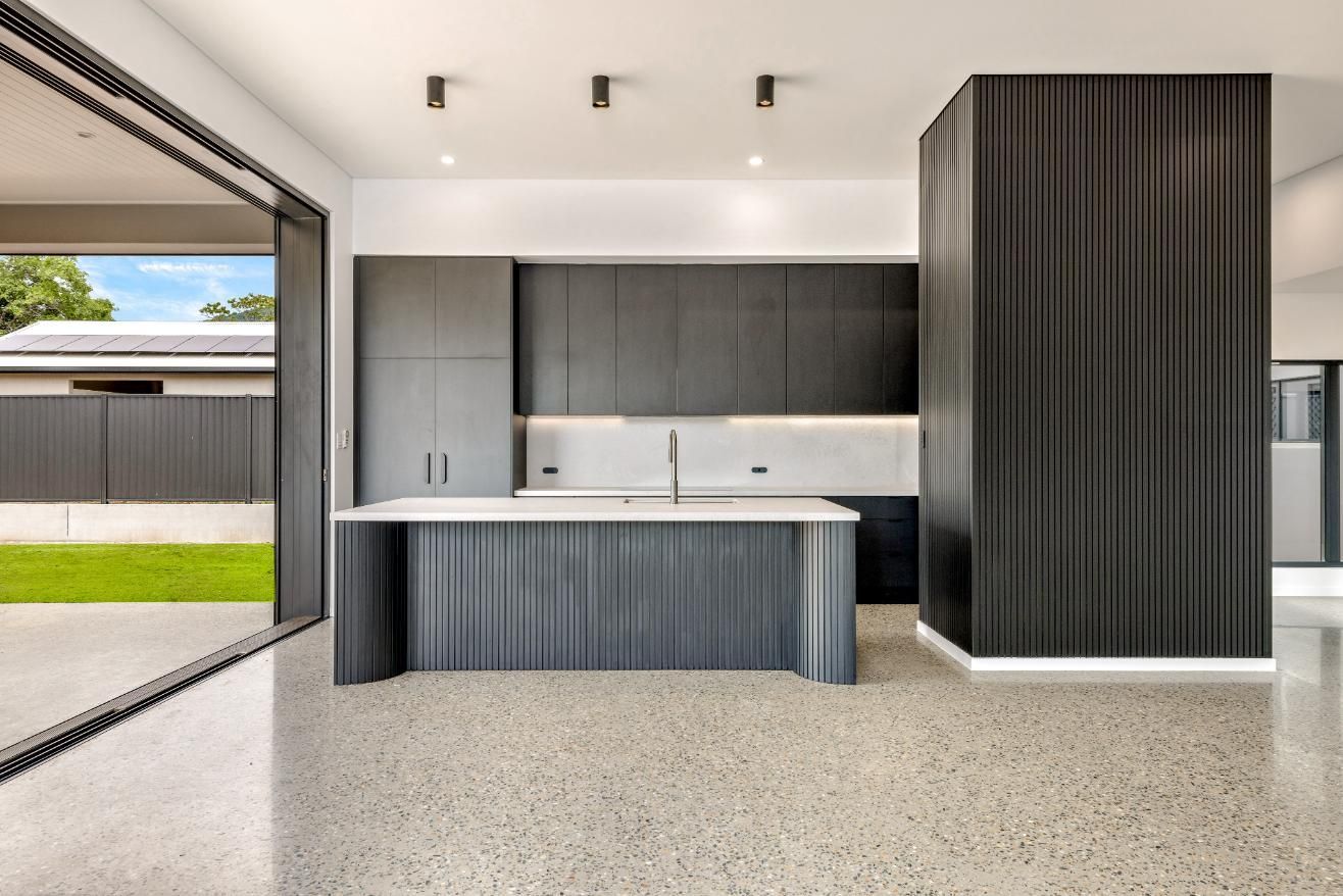 A Kitchen with Black Cabinets and A White Counter Top — Ashlee Jones Homes in Gordonvale, QLD