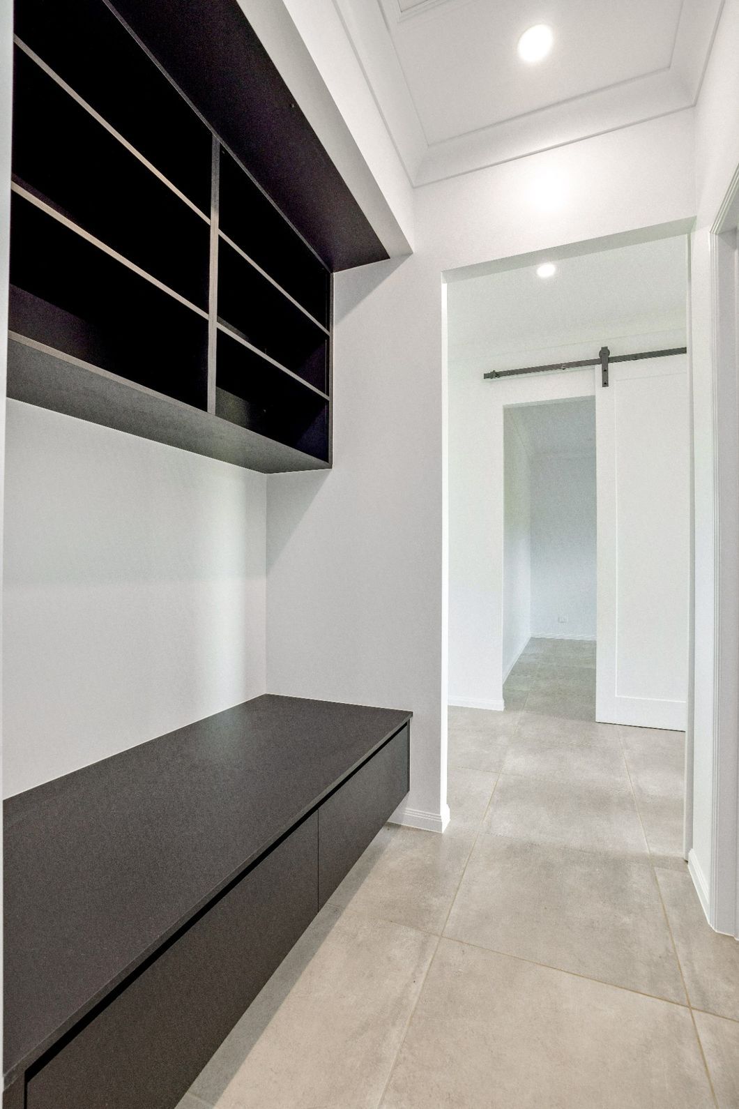 A Hallway With a Sliding Barn Door and a Bench — Ashlee Jones Homes in Gordonvale, QLD