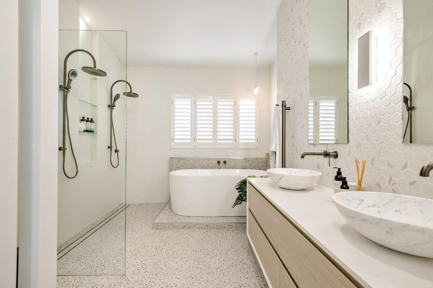 A Bathroom With Two Sinks, a Bathtub, and a Walk in Shower — Ashlee Jones Homes in Gordonvale, QLD