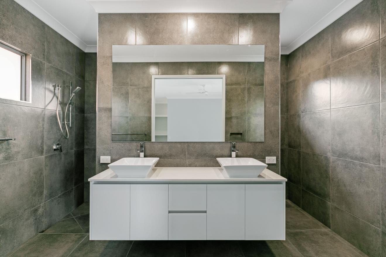 A Bathroom With Two Sinks and a Large Mirror — Ashlee Jones Homes in Gordonvale, QLD