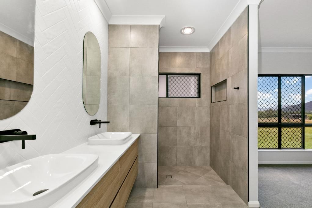 A Bathroom With Two Sinks and a Walk in Shower — Ashlee Jones Homes in Gordonvale, QLD