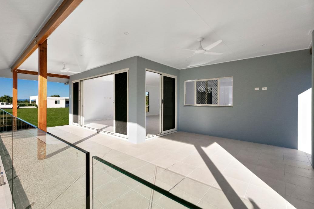 A Balcony With a Glass Railing and Sliding Glass Doors — Ashlee Jones Homes in Gordonvale, QLD