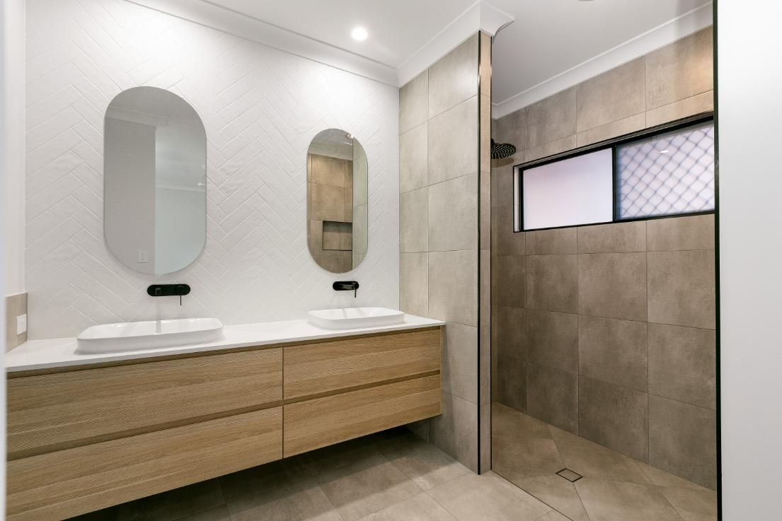 A Bathroom With Two Sinks and a Walk in Shower — Ashlee Jones Homes in Gordonvale, QLD