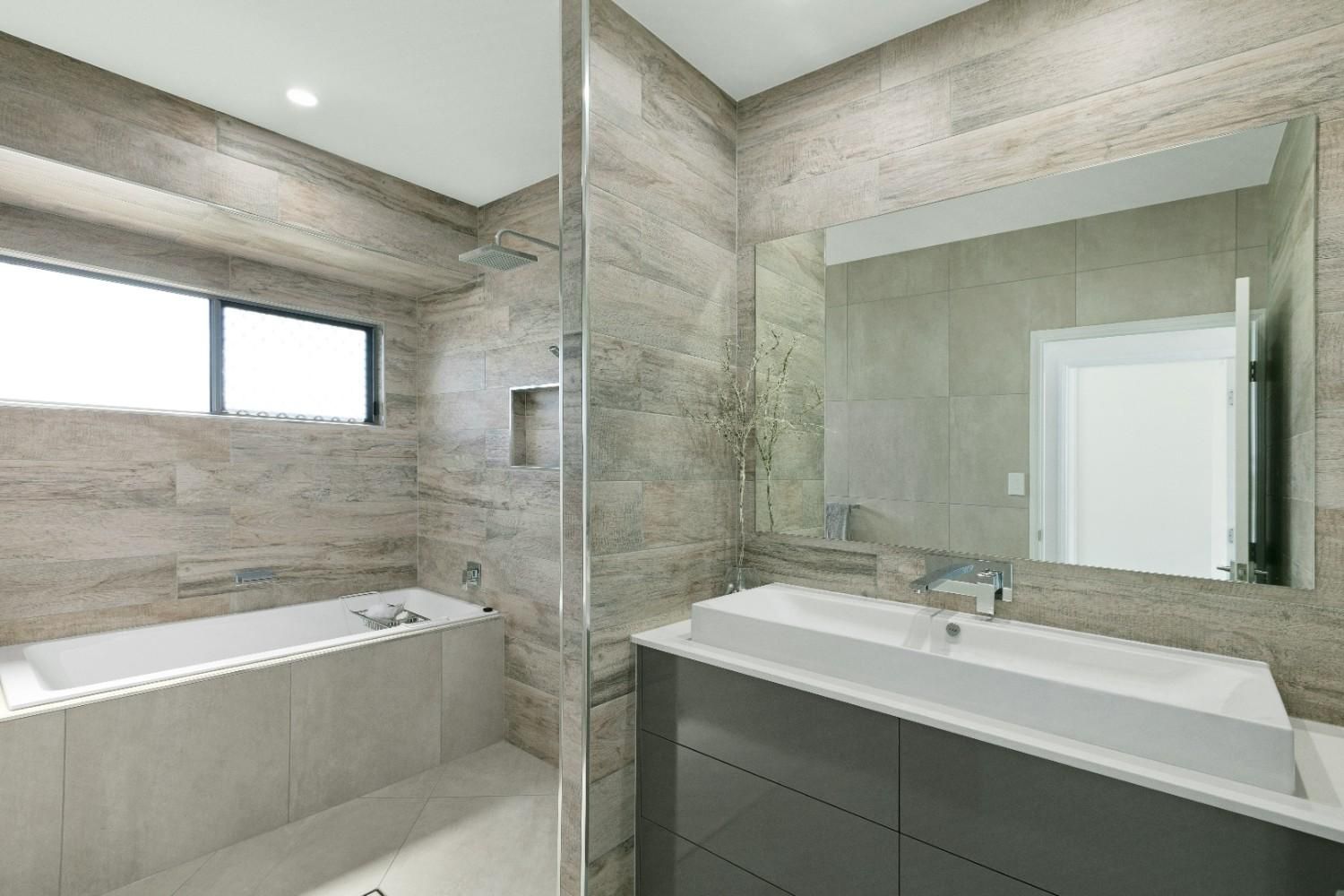 A Bathroom With a Sink, Tub, Shower and Mirror — Ashlee Jones Homes in Gordonvale, QLD