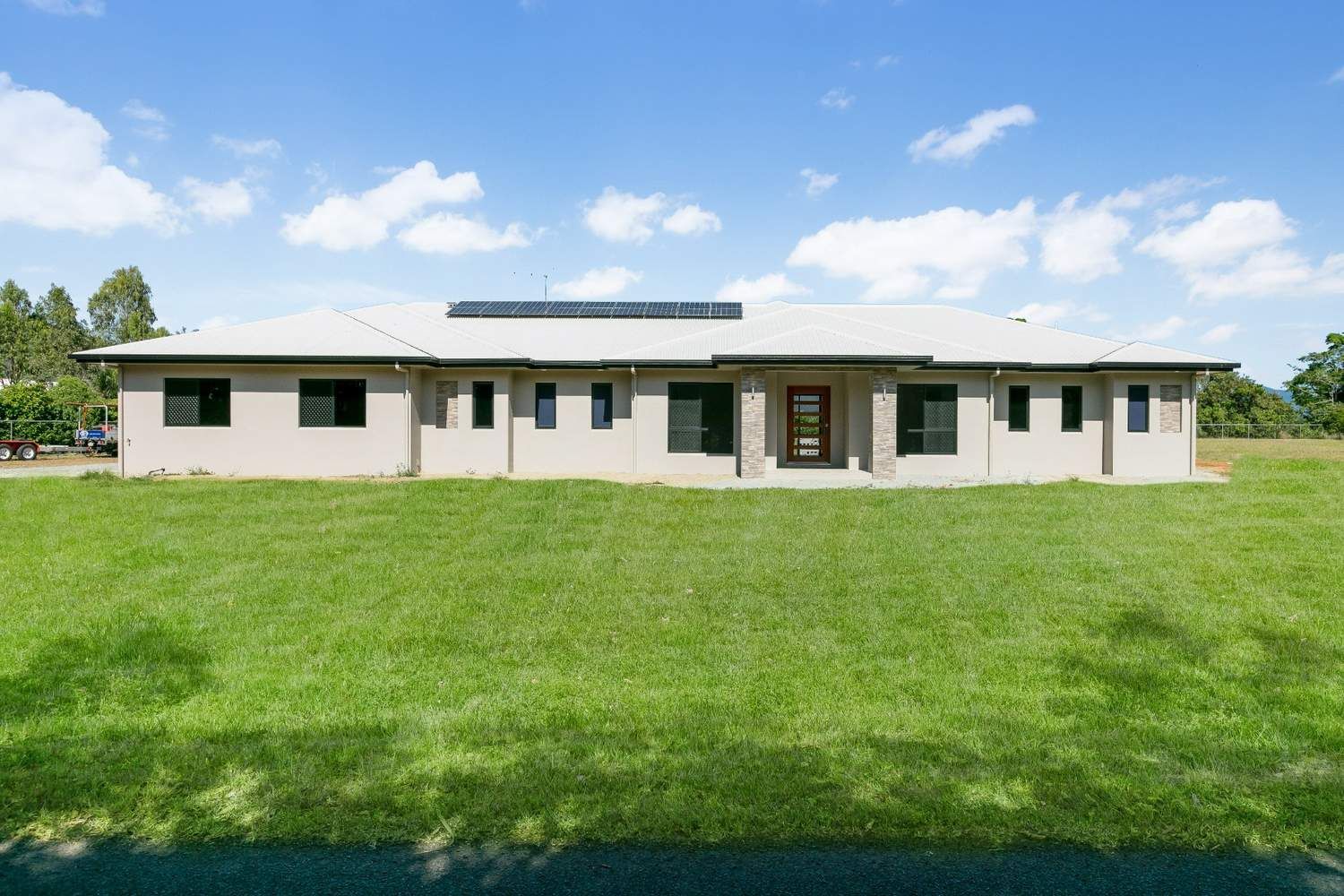 A Big House is Located Amid a Lush, Grassy Landscape — Ashlee Jones Homes in Gordonvale, QLD