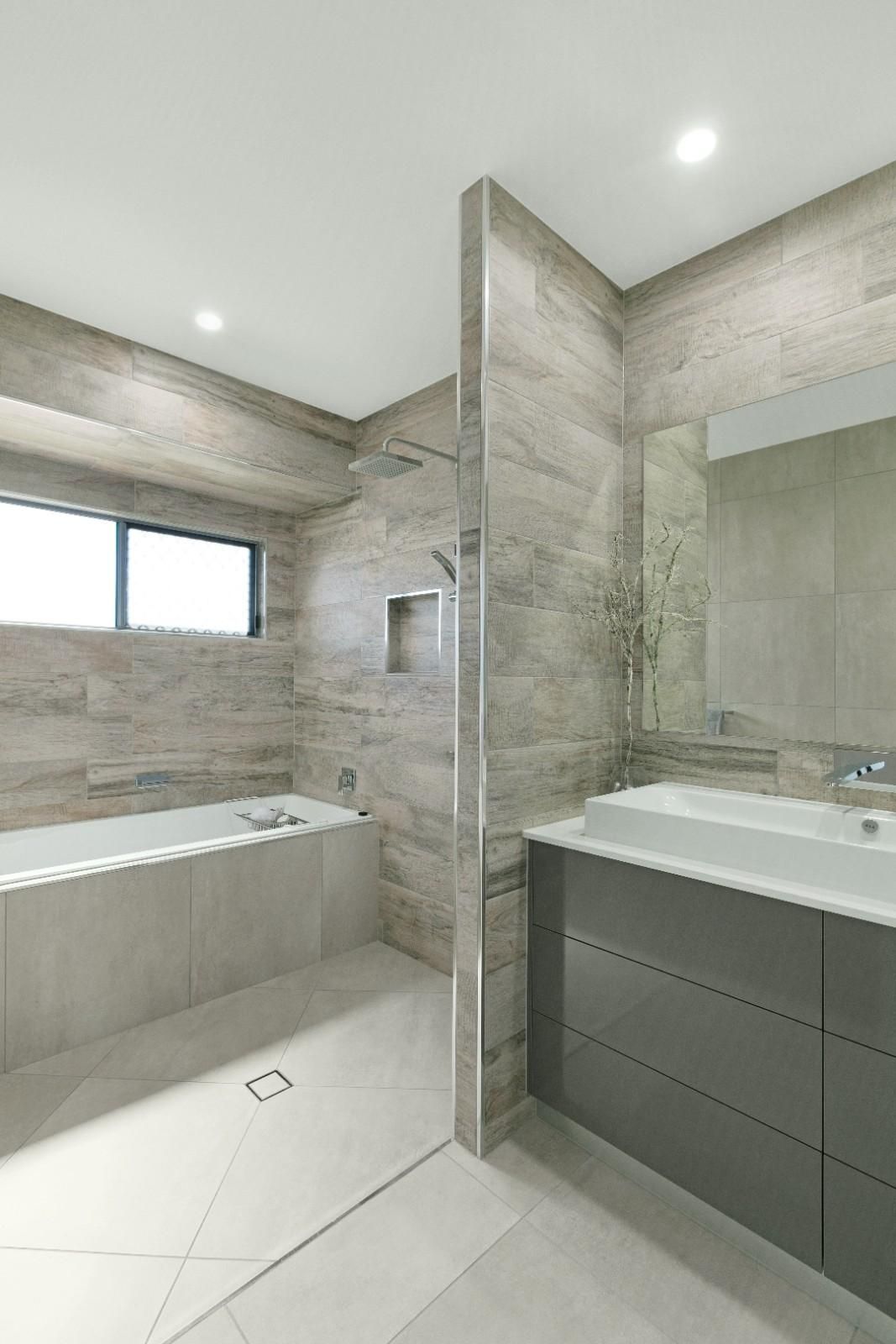 A Bathroom With a Tub, Sink, Mirror and Shower — Ashlee Jones Homes in Gordonvale, QLD