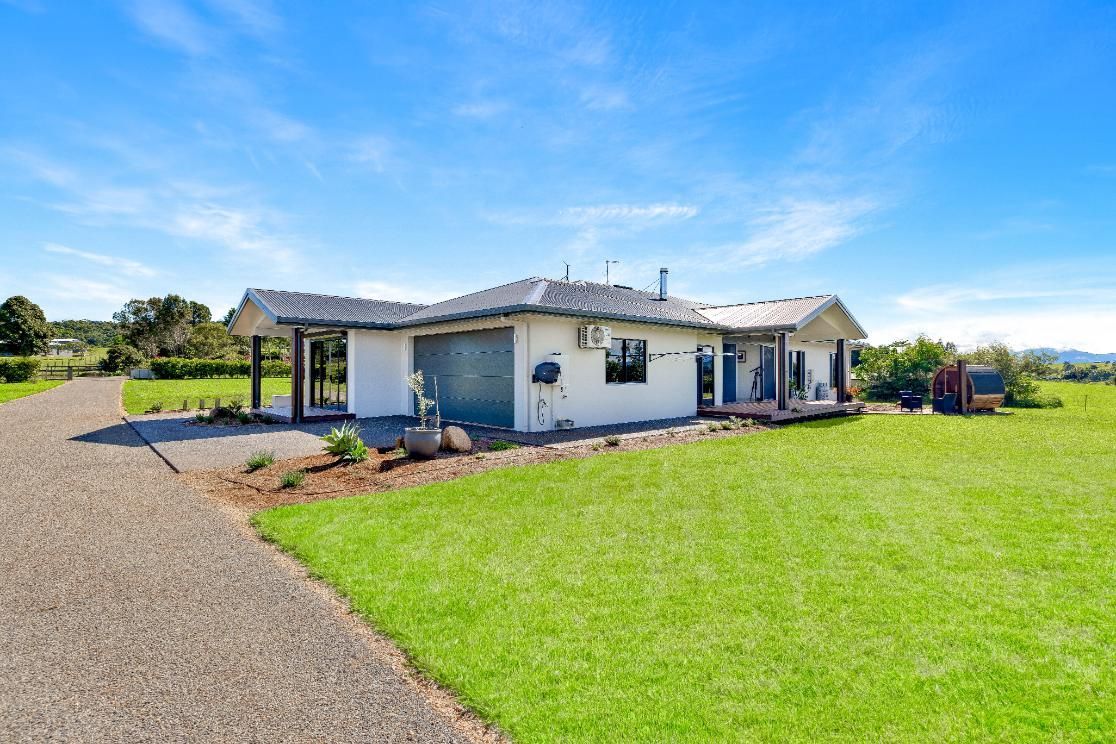 A White House is Sitting on Top of a Lush Green Field — Ashlee Jones Homes in Gordonvale, QLD