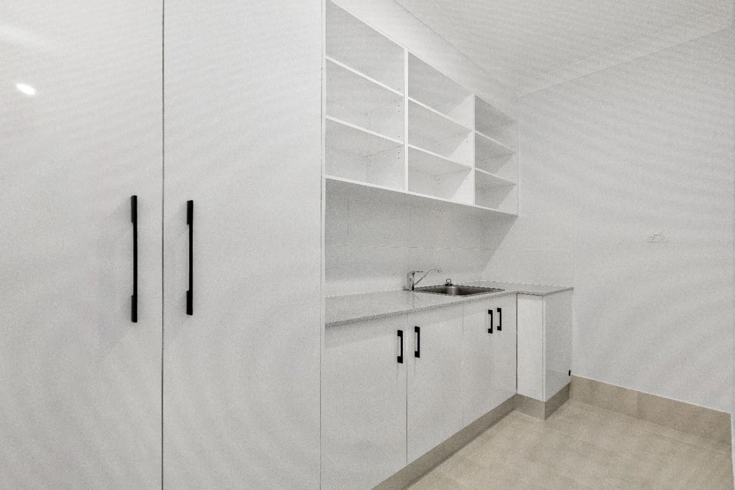 A Kitchen With White Cabinets and Shelves and a Sink — Ashlee Jones Homes in Gordonvale, QLD