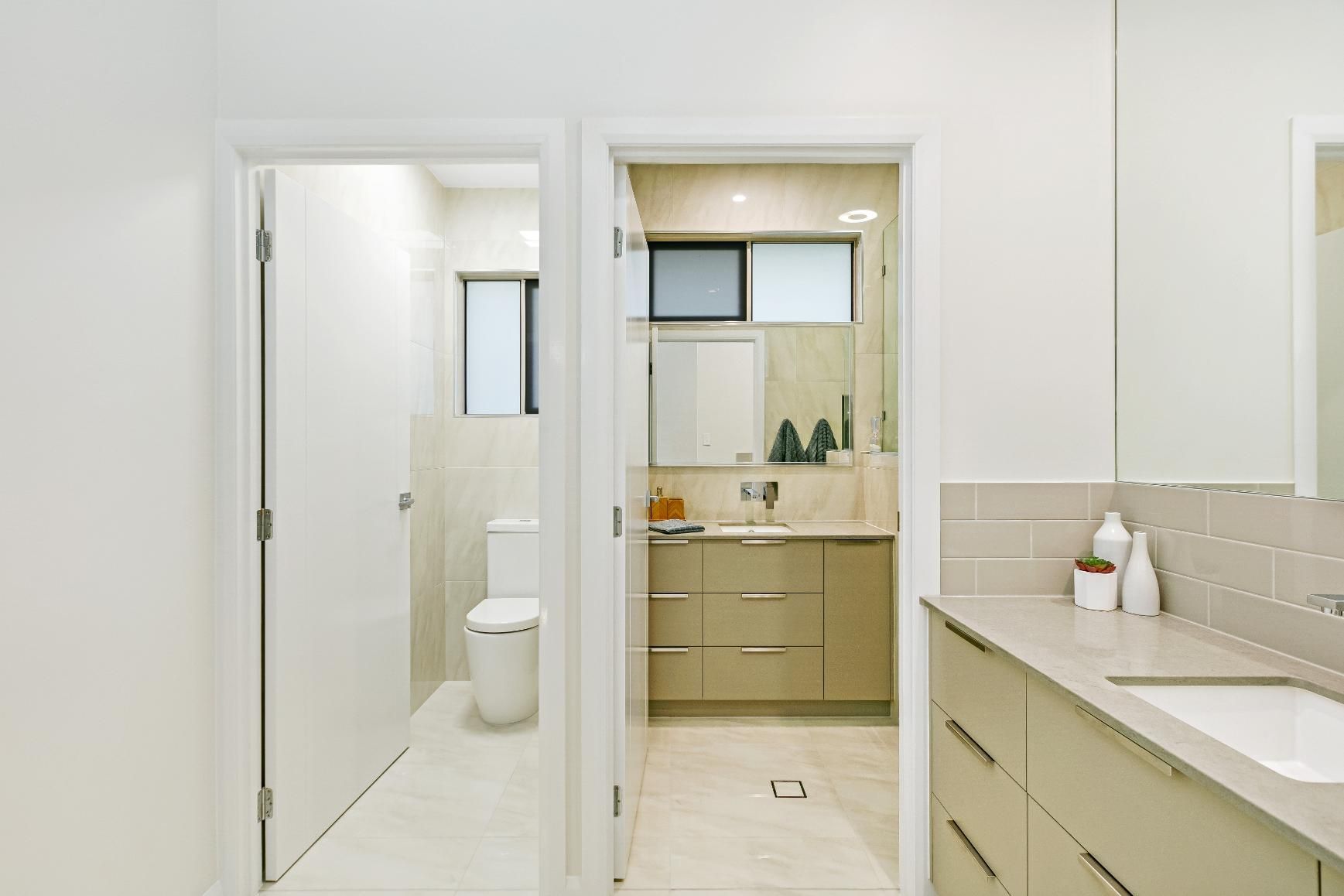 A Bathroom With a Sink, Toilet and Mirror — Ashlee Jones Homes in Gordonvale, QLD
