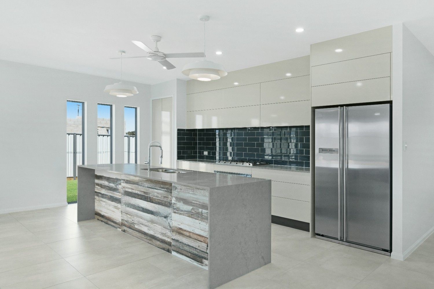 A Kitchen With Stainless Steel Appliances and a Large Island — Ashlee Jones Homes in Gordonvale, QLD