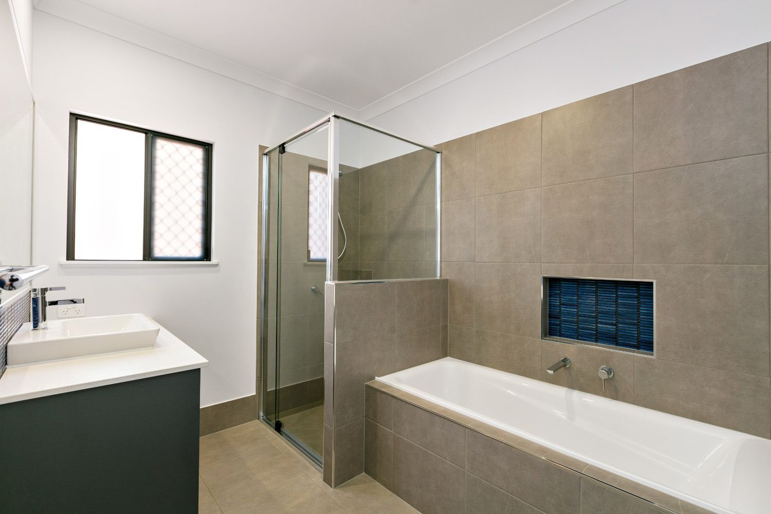 A Bathroom With a Bathtub, Sink, and Shower — Ashlee Jones Homes in Gordonvale, QLD