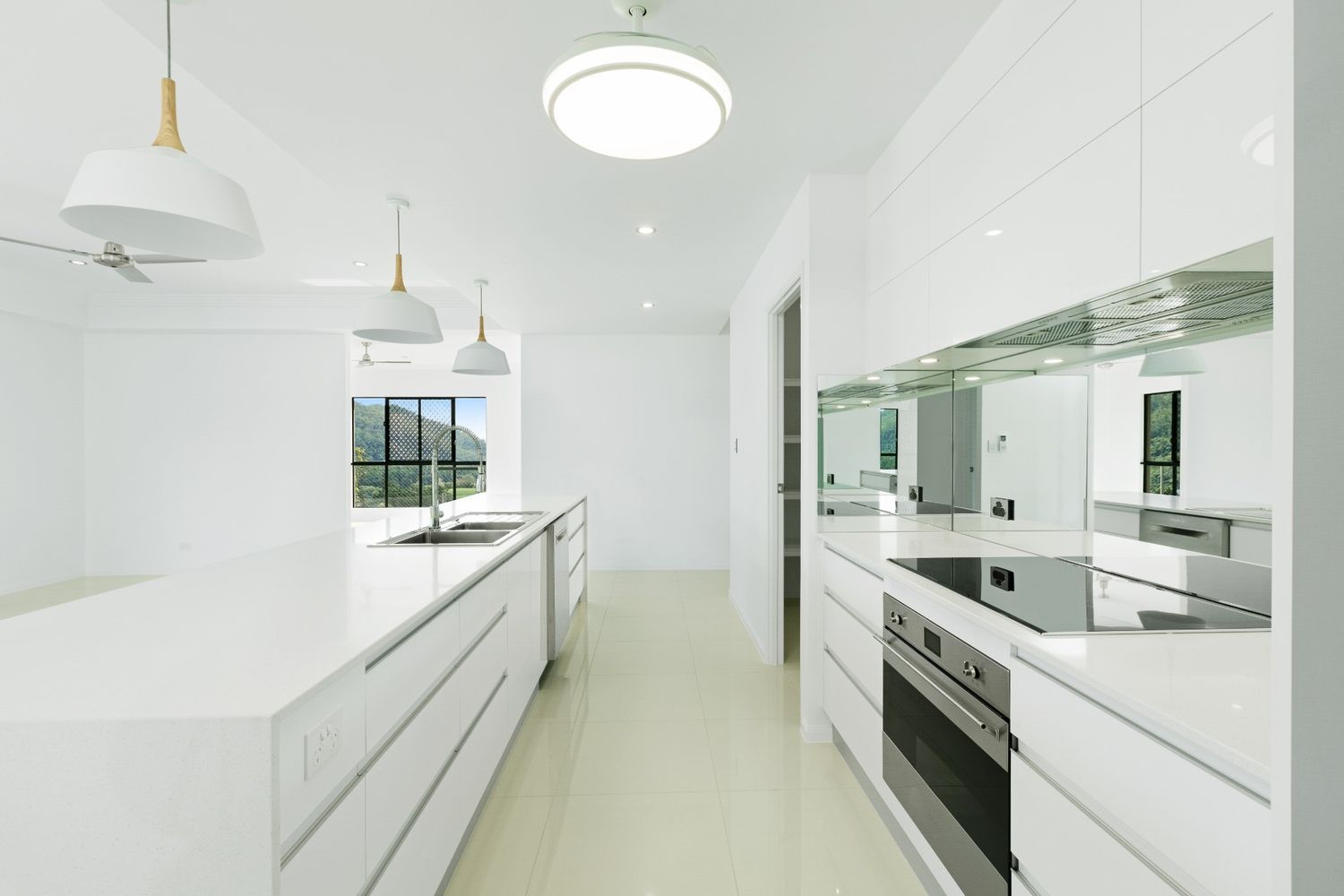 A Kitchen With White Cabinets and Stainless Steel Appliances — Ashlee Jones Homes in Gordonvale, QLD