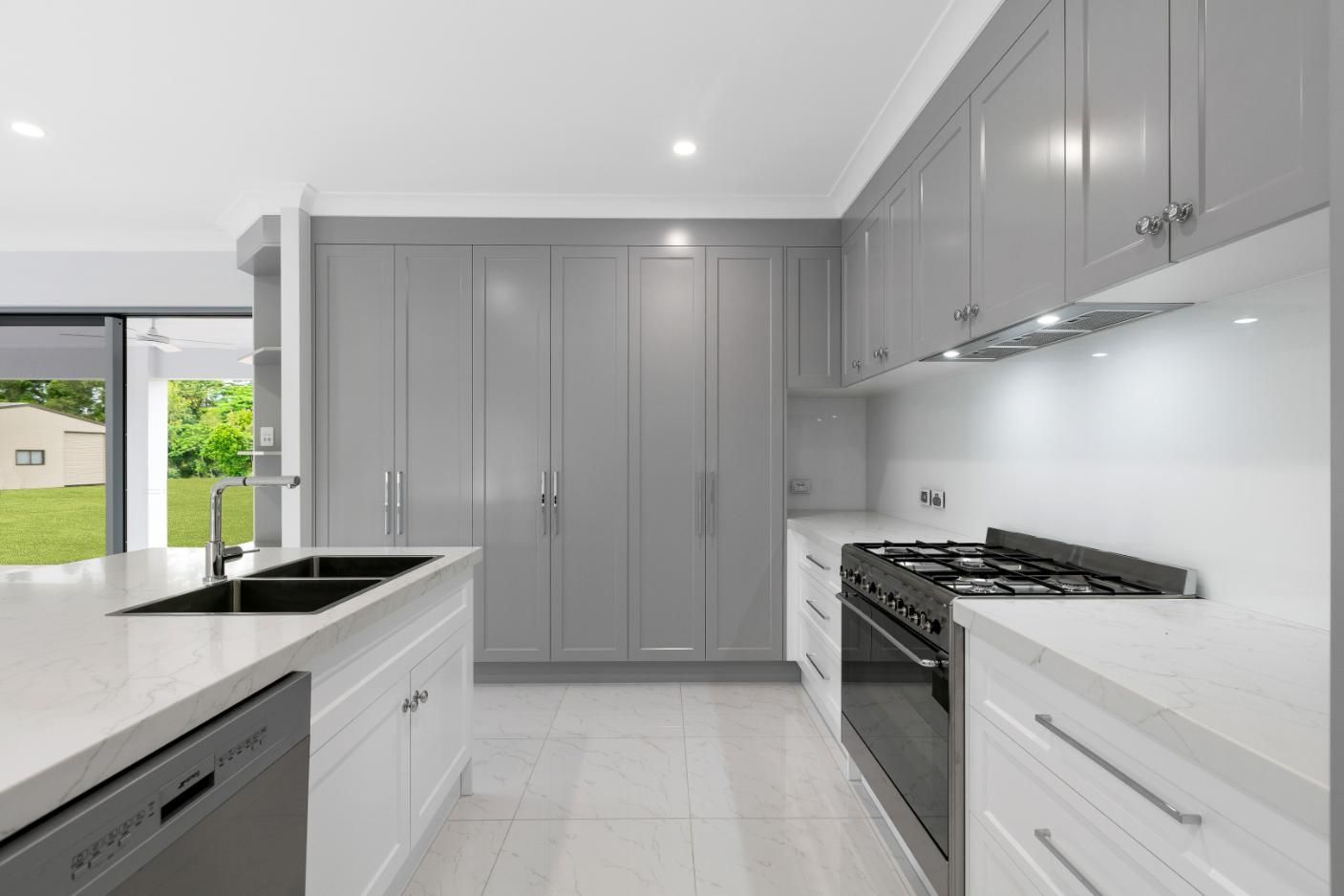 A Kitchen With Gray Cabinets, White Countertops, a Stove and a Sink  — Ashlee Jones Homes in Gordonvale, QLD